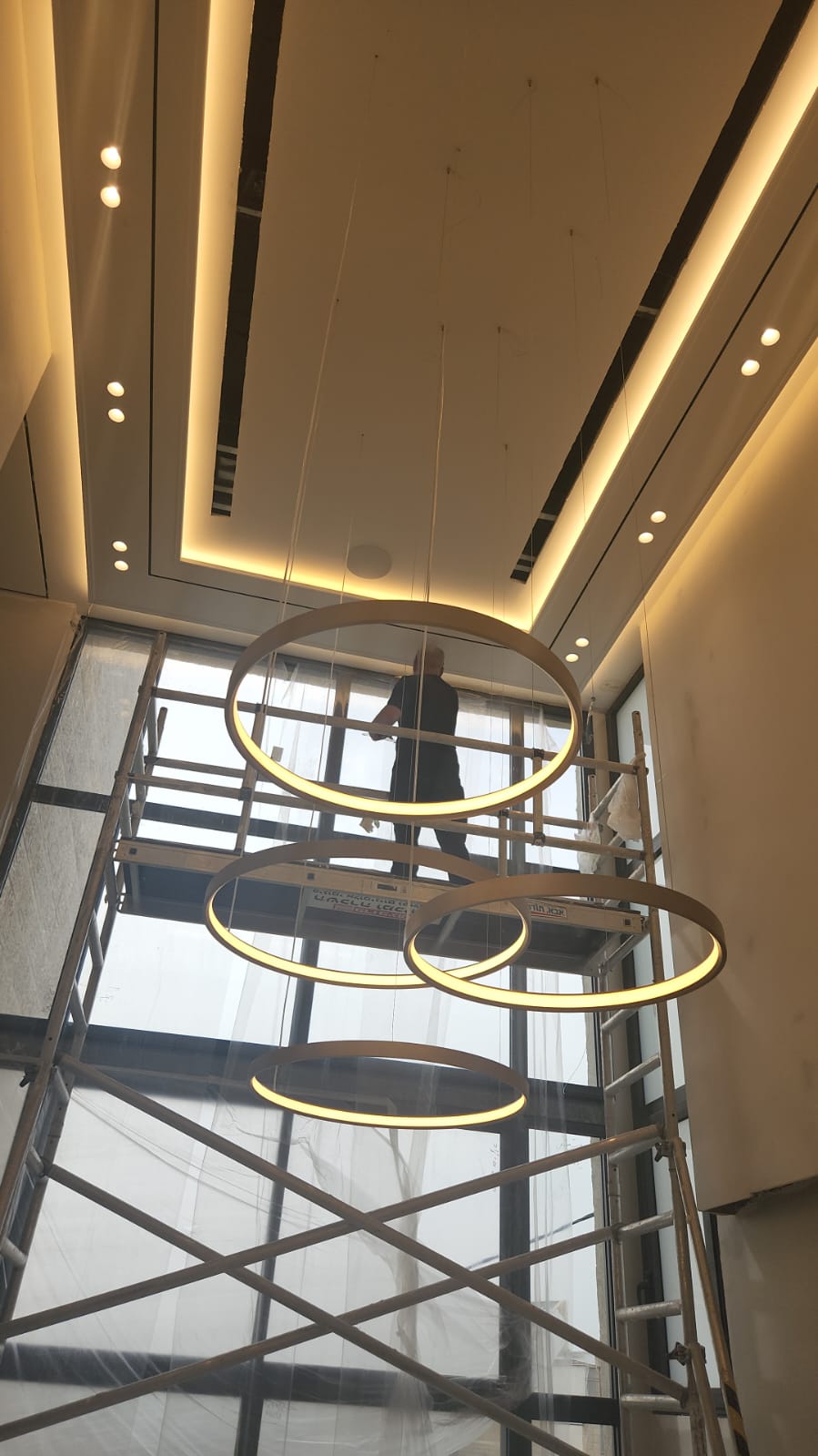 לובי גבוה עם תאורת טבעות זהובה — עיצוב של משרד DMO